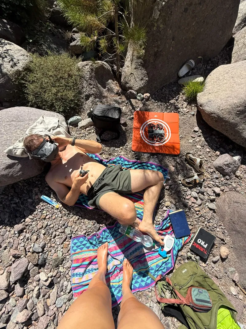 Break between granite boulders with drone goggles and a drone on a landing pad