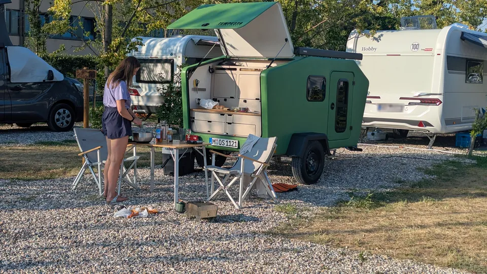 Dinner in front of the Glide with its rear kitchen open at the campsite by Lake Garda