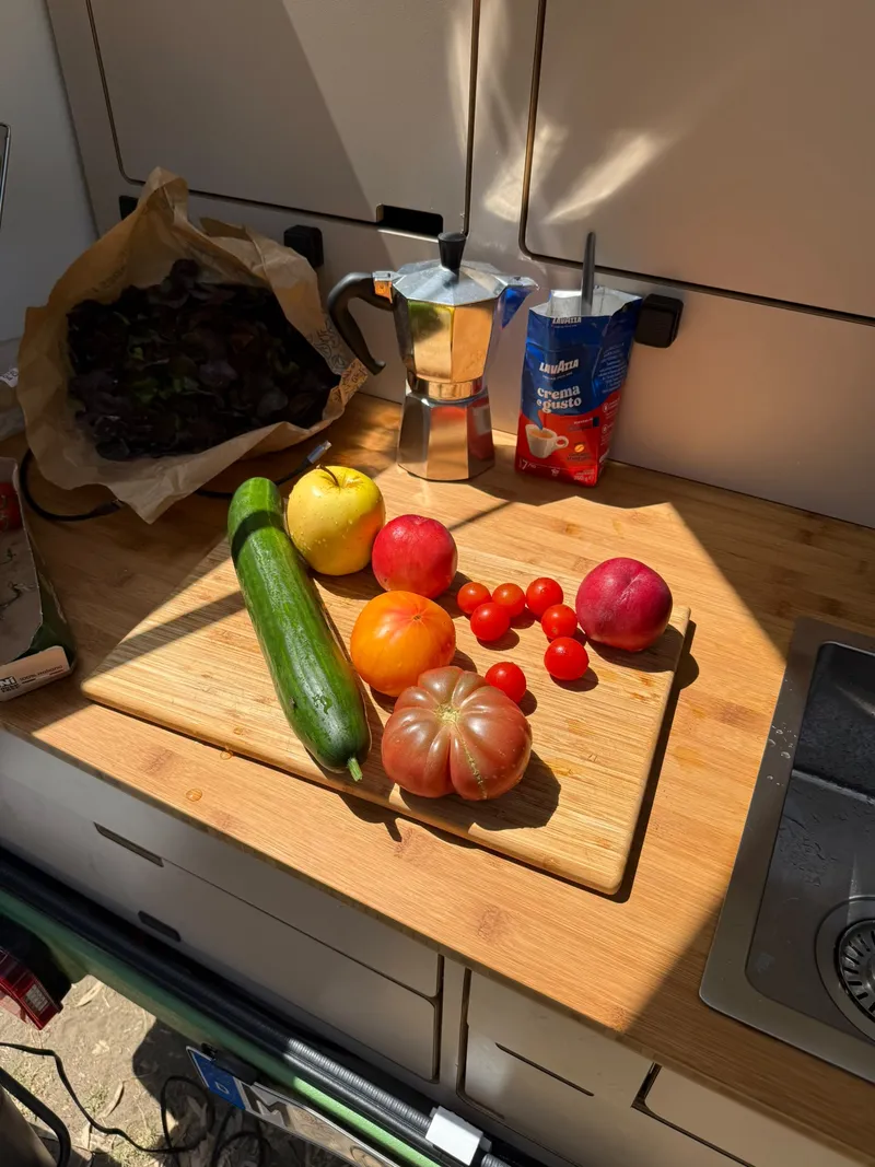 Vegetables, fruit, a moka pot and coffee on the bamboo worktop of the rear kitchen