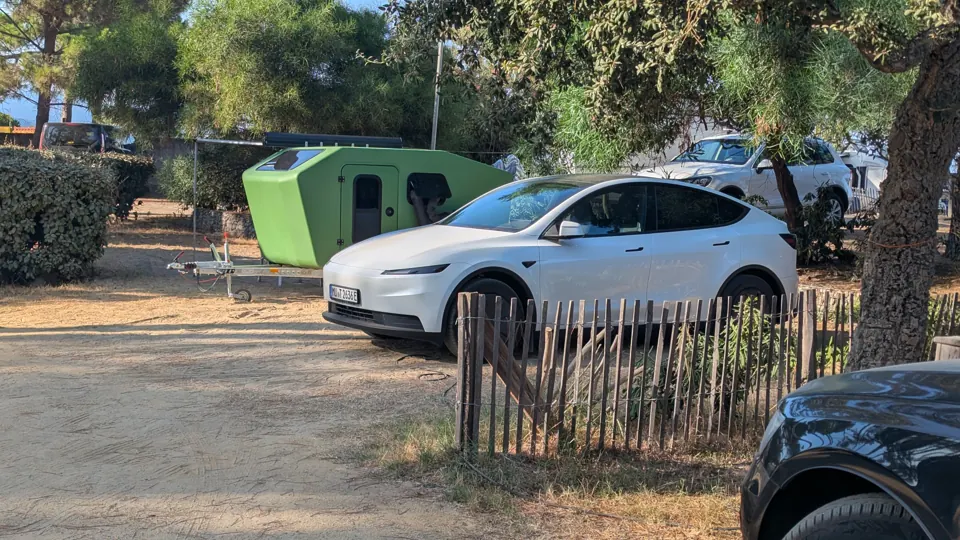 Glide and electric car at a campsite under trees