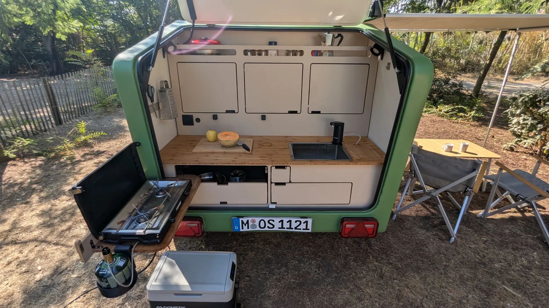Open rear kitchen of the Glide with bamboo worktop, sink, drawers and swung-out gas stove