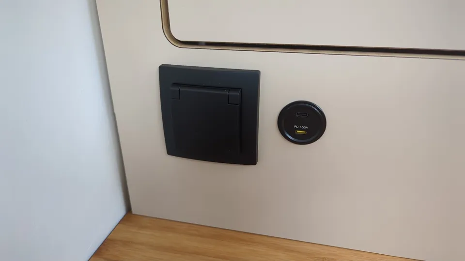 Schuko socket with flip cover and USB-C port (100 W) on the cabinet wall of the Glide