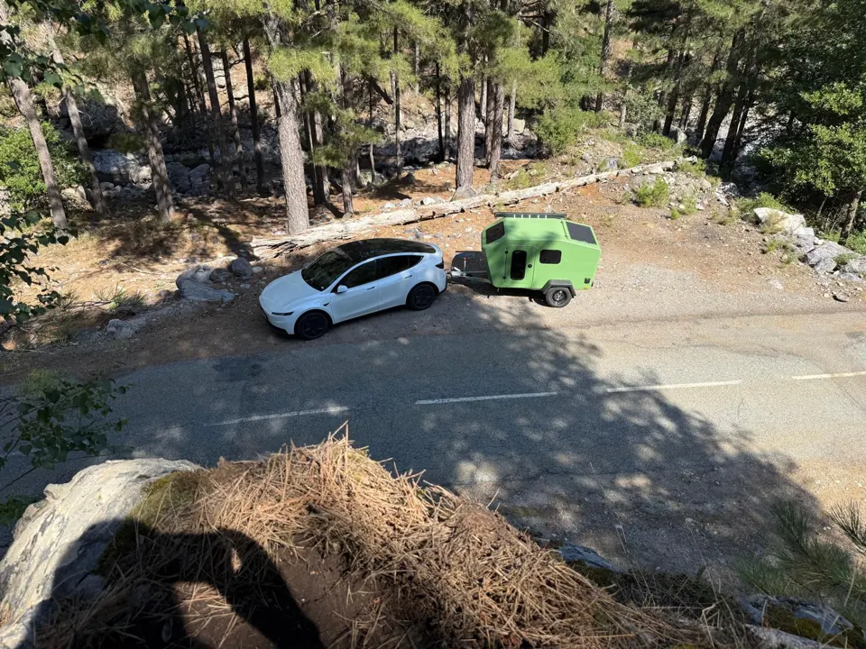 Car and trailer from above on a mountain road, the solar panel on the Glide roof